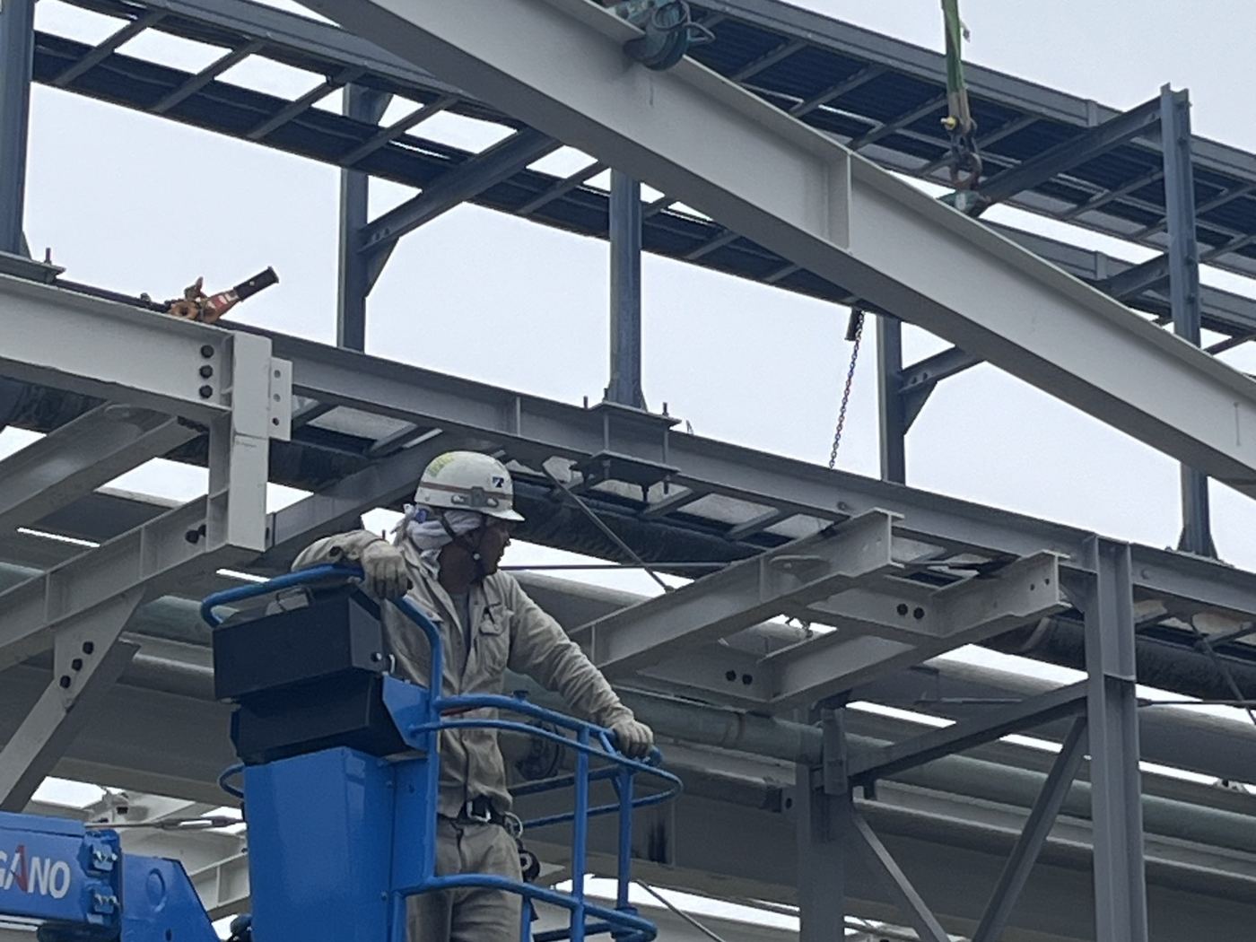 高所作業車から鉄骨梁を建て込む作業