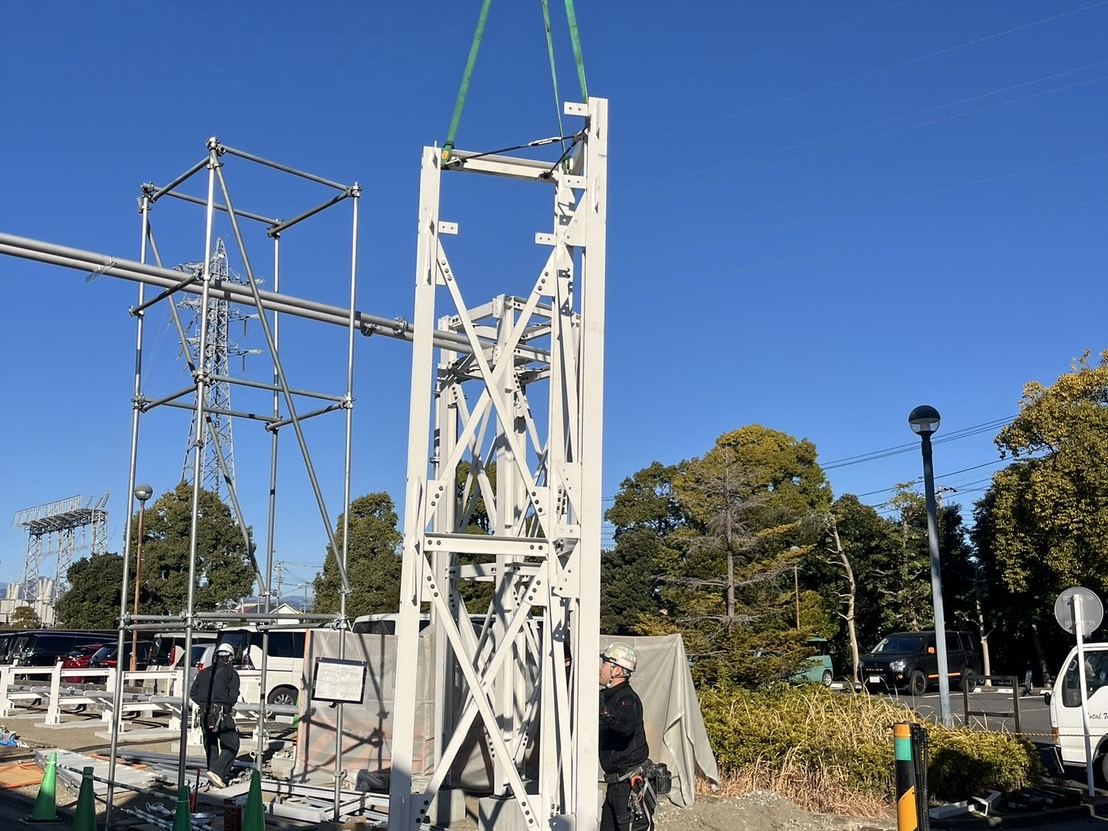 クレーンで鉄骨タワーを吊り上げ建て起こす様子